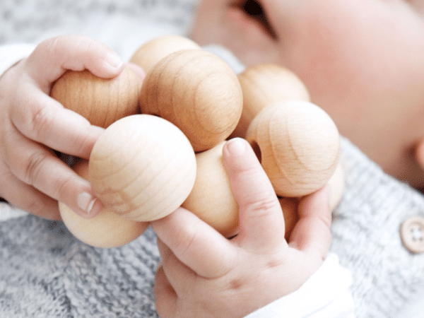 Bébé joue au sol et apprécie attraper des objets avec ses mains
